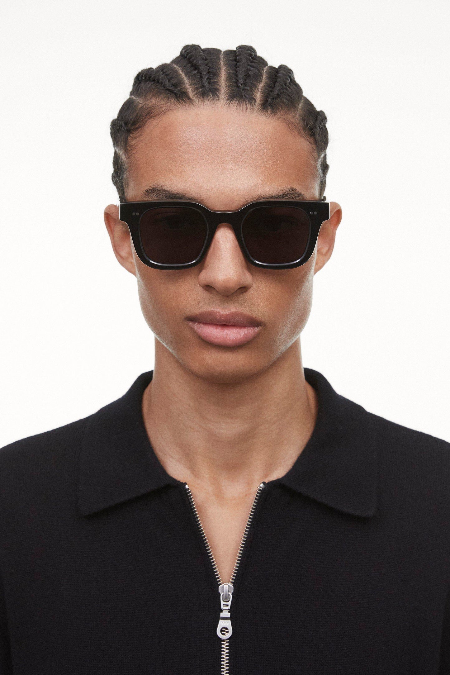 Black Chimi 04 sunglasses on a male model of color with cornrows. The glasses have square frames and a dark lens.
