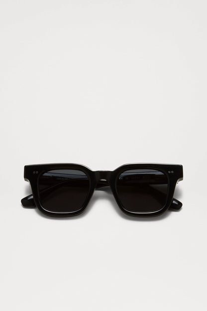 Chimi 04 sunglasses in black coloring folded together. Featuring square frames, dark lenses, and two small silver dots on the top corners of the frame.