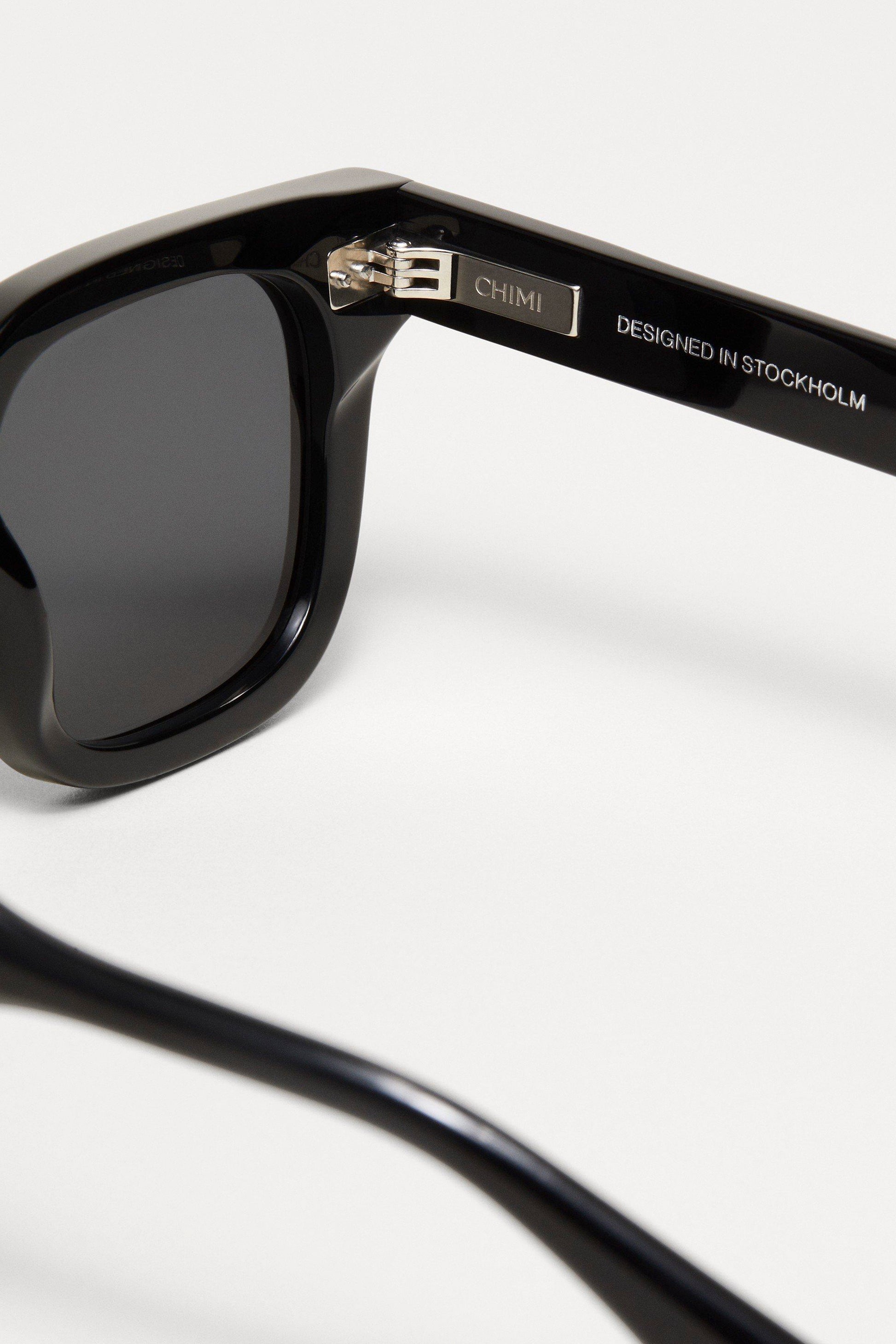 Closeup of the Black Chimi 04 sunglasses. Showing the enravings on the inside of the black square frame. 