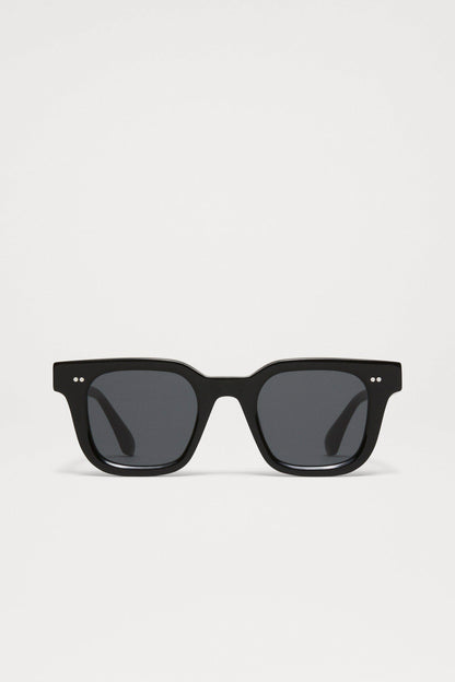 Chimi 04 sunglasses in color black with square frames, dark lenses, and two small silver dots on the top corners of the frame.