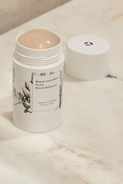 Deodorant with smell No. 04 Bois de Balincourt from Maison Louise Marie that has been opened. Standing on a marble table. 